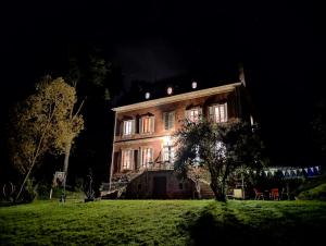 ein großes Gebäude in der Nacht mit eingeschaltetem Licht in der Unterkunft Appartement au coeur de la Suisse normande in Thury-Harcourt