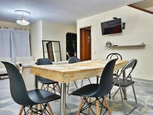 comedor con mesa de madera y sillas en HOSTAL - Casa Rionegro -10 min del aeropuerto, en Rionegro