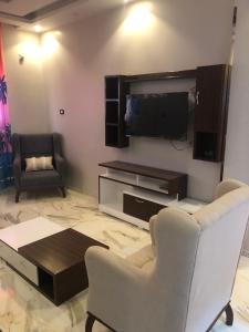 uma sala de estar com 2 cadeiras e uma televisão de ecrã plano em New Villa Carimo em El Quseir