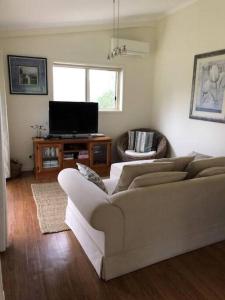 a living room with a couch and a television at Fairmont Cottage in Woodhill