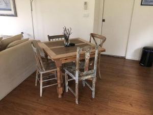 a wooden table and chairs in a living room at Fairmont Cottage in Woodhill