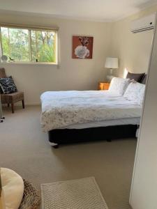 a bedroom with a large bed and a window at Fairmont Cottage in Woodhill +1 photo