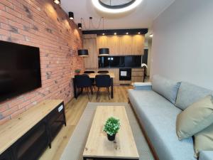 a living room with a couch and a brick wall at STARCO Apartamenty Centrum in Stargard