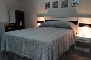 1 dormitorio con 1 cama grande y 2 mesitas de noche en Casa Magnolia, en Tarija
