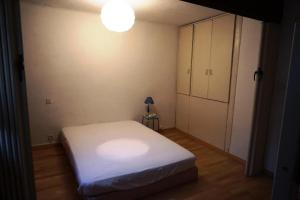 Dormitorio pequeño con cama blanca y lámpara en Résidence Ecrins 107262 en Orcières