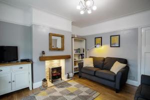 a living room with a couch and a fireplace at Stylish and cosy cottage in the heart of Yorkshire in Leeds