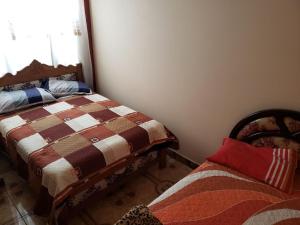 a bedroom with two beds and a window at Departamento Acogedor _ EDIF. MAIRANA in Cochabamba