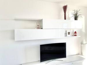 uma sala de estar com lareira e prateleiras brancas em [10 min. da Sanremo] Appartamento Vista Mare em Taggia