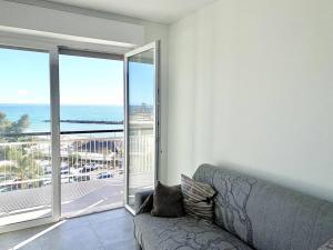 uma sala de estar com um sofá e vista para o oceano em [10 min. da Sanremo] Appartamento Vista Mare em Taggia
