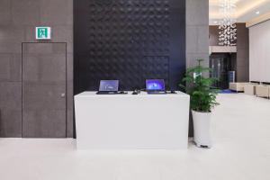 a white counter with two laptops on it in a lobby at Uljiro Coop Residence Dongdaemun in Seoul