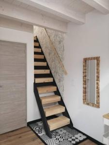 Una escalera en una habitación con una pared blanca en Studio aux Granges du Vilaret, en Clairvaux-les-Lacs