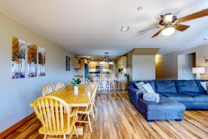 een woonkamer met een blauwe bank en een tafel en stoelen bij Tigers Den - Lower in Arkdale