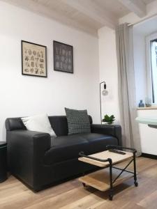 sala de estar con sofá negro y mesa en Studio aux Granges du Vilaret, en Clairvaux-les-Lacs