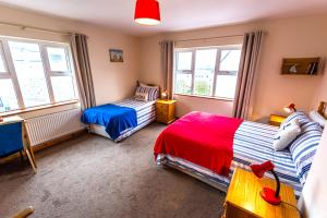 a bedroom with two beds and two windows at Seawinds Bed and Breakfast in Killybegs