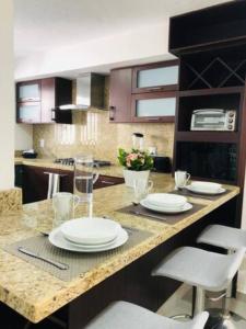 a kitchen with a counter with white plates on it at Urban Chapalita in Guadalajara