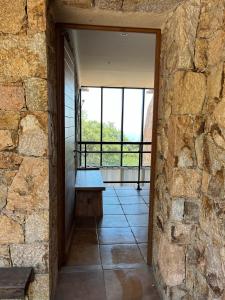 サリ・ソランザラにあるMaison En Pierre Corse Vue Merの窓付きの部屋のベンチ付きの石壁