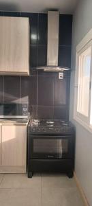 a kitchen with a black stove and a microwave at Sobrado Completo Belíssima in Pelotas