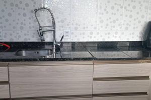 a kitchen sink with a faucet on top of it at Sobrado Completo Belíssima in Pelotas