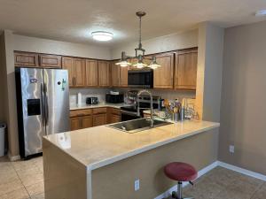 a kitchen with a sink and a refrigerator at A stylish and Comfy Place to Stay in Gainesville
