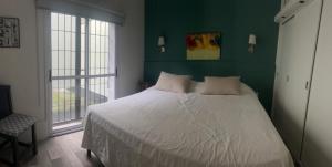 ein Schlafzimmer mit einem großen Bett mit einer grünen Wand in der Unterkunft Casa Gutiérrez in Godoy Cruz