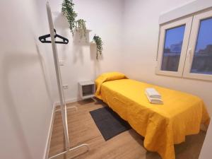a room with a bed with a yellow blanket at Vivienda El Viajero in Valverde