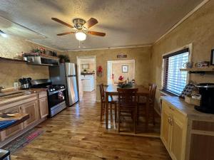 a kitchen with a table and a ceiling fan at Cuddle Up in Ruidoso