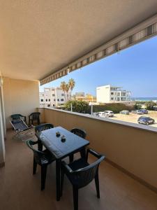 a balcony with a table and chairs and a large window at La casa al Mare in Erice