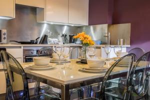 una cocina con una mesa con sillas y flores. en Luxurious & Spacious Apartment en Reading
