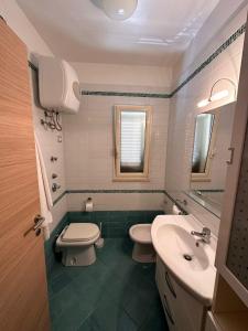 a bathroom with a toilet and a sink at La casa al Mare in Erice