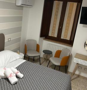 1 Schlafzimmer mit einem Bett, 2 Stühlen und einem Tisch in der Unterkunft La Chicca di Sofy in Orvieto