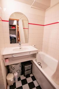 a bathroom with a sink and a tub and a mirror at Résidence Les Melezets 1 - Studio pour 5 Personnes 193079 in Modane