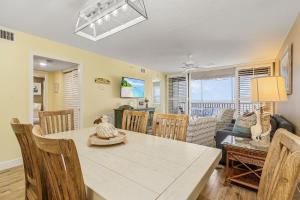 a dining room and living room with a table and chairs at Spectacular Gulf Front Condo on the North end of the Island condo in Fort Myers Beach
