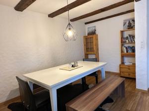 a dining room with a white table and chairs at charmante 3,5 Zimmer Wohnung in Bauernhaus in Volketswil