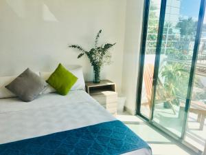 Un dormitorio con una cama con un jarrón. en Casa Ohana By Utopia, en Playa del Carmen