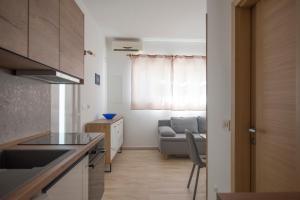 małą kuchnię z kanapą i oknem w obiekcie Apartmani Tomica w mieście Jesenice
