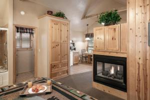 a living room with a fireplace and a kitchen at Shadow Mountain Lodge and Cabins in Ruidoso