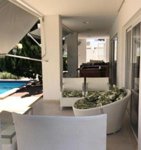 een patio met stoelen, een tafel en een zwembad bij Casa Villas in Lauro de Freitas