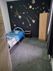 1 dormitorio con cama y pared con planetas en Central home en Bruselas