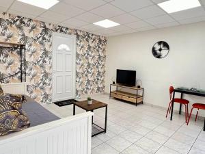ein Wohnzimmer mit einem Sofa und einem TV in der Unterkunft Le petit Penon ~ T1 Bis avec parking /clim /Fibre in Saint-Georges-lès-Baillargeaux