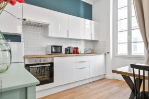 a kitchen with white cabinets and a stove top oven at La Loge Vieux-Port in Marseille