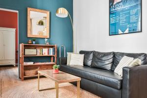 a living room with a black leather couch and a table at La Loge Vieux-Port in Marseille +9 photos