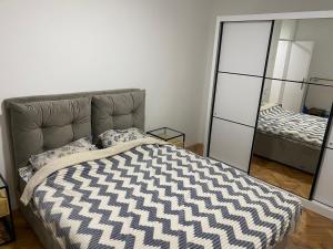 a bedroom with a bed and a mirror at Regal Comfort Apartment in Pirot