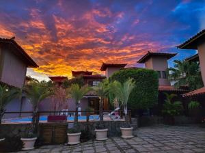 een zonsondergang boven een villa met palmbomen op een binnenplaats bij Domus 7 in Búzios