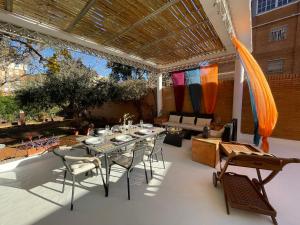 un patio con mesa y sillas en El Jardin de la Palmera, en Sevilla
