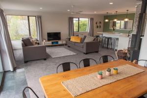 a dining room and living room with a table and chairs at Pip's Lakeview Retreat in Wanaka