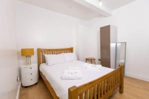una camera da letto con un letto con lenzuola bianche e uno specchio di Modern and Luxury House for 8 a Gillingham