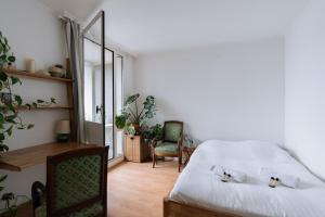 um quarto com uma cama, uma secretária e uma cadeira em Beautiful Family-friendly 2BD Apart Belleville em Paris