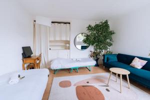 uma sala de estar com um sofá azul e uma mesa em Beautiful Family-friendly 2BD Apart Belleville em Paris