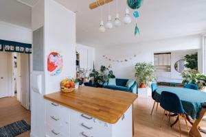 uma cozinha e sala de jantar com uma mesa e cadeiras azuis em Beautiful Family-friendly 2BD Apart Belleville em Paris