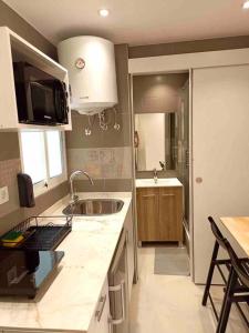- une cuisine avec un évier et un comptoir dans l'établissement Apartamentos LH frente al metro Barcelona-Aeropuerto, à L'Hospitalet de Llobregat
